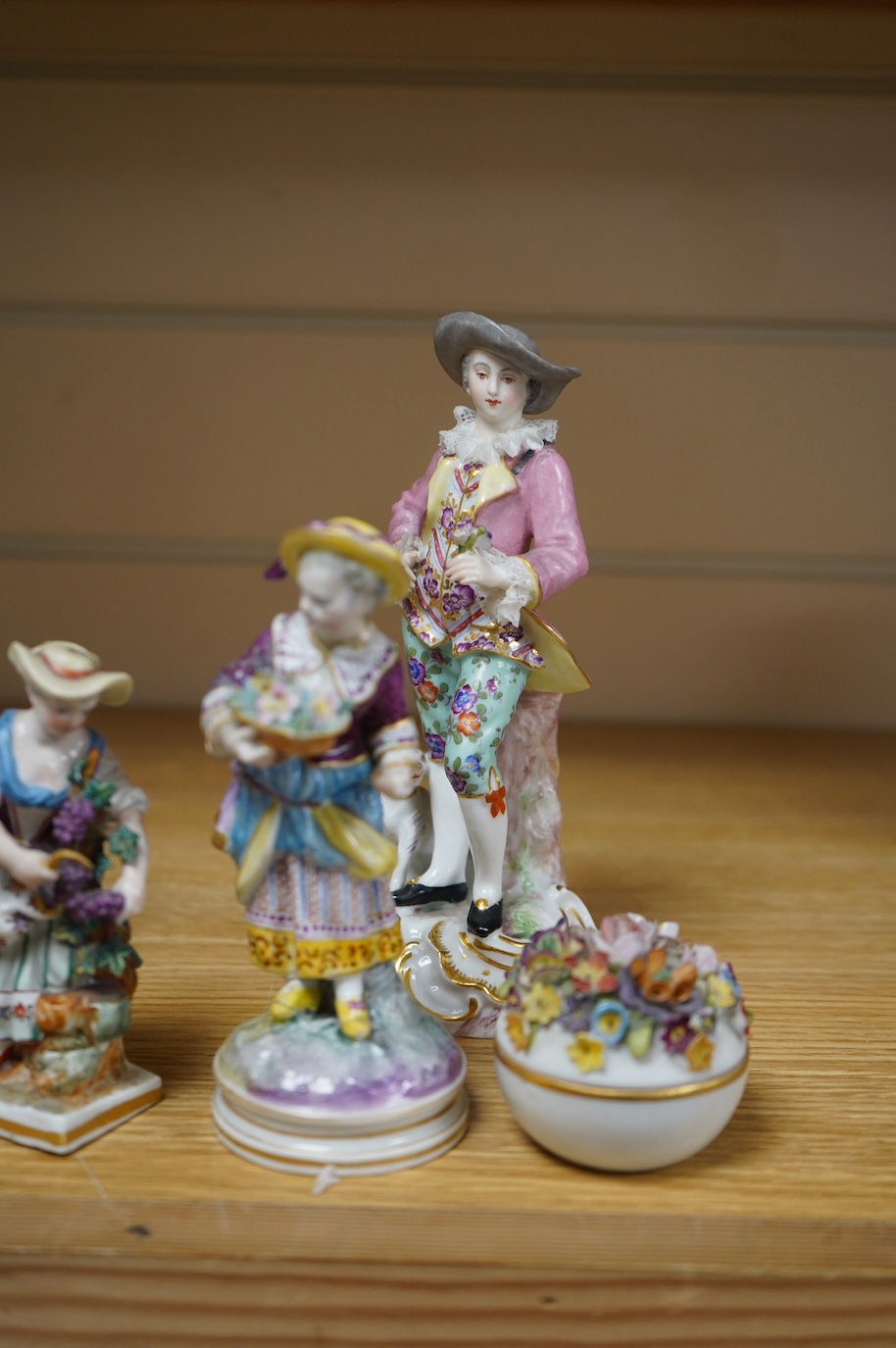 Eight various German porcelain figures, some with crossed sword marks to the bases and a floral encrusted pot and cover, largest 19cm high. Condition - fair, some losses